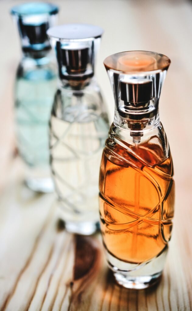 Elegant perfume bottles with colorful fragrances arranged on a wooden surface.